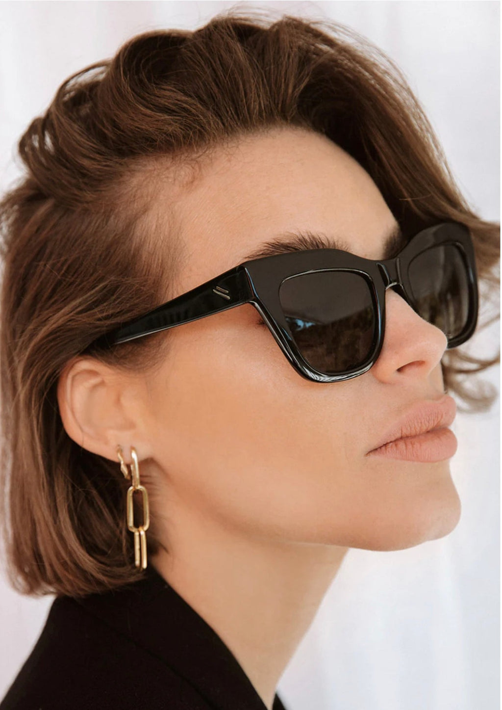 Dusk - Shiny Black/Grey Polarised, by Bask Details:  Crafted from glossy acetate, the Dusk features a slightly angular and exaggerated cat-eye silhouette for the modern-day wearer.  Fitted with our signature polarised lenses, you will find our icon detailed in gold at the temples.