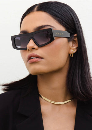 Veil - Shiny Black/Grey Polarised, by Bask Details:  Featuring a sleek shield silhouette, the Veil is designed for the sun-seekers who love to push the boundaries of fashion. Available in 3 contemporary colour ways, Veil is crafted with an acetate frame, luxurious temple detailing and fitted with a TAC gradient polarised lens. This style is your go-to chic, yet sun-smart, eyewear solution.