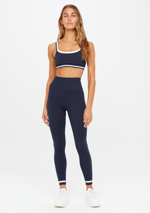 Form Seamless 25" Midi Pant - Navy, by The Upside Find your happy place in our Form Seamless 25In Midi Pant  Solid knitted seamless midi pant Mid rise waistband with 7/8 length leg Contrasting classic sporty stripes at cuffs Knitted arrow logo at back leg Moisture control properties