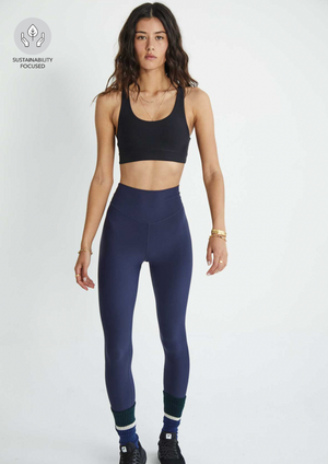 Peached 28" High Rise Pant - Navy, by The Upside Feel comfortable in your own skin with a little help from our Peached High Rise 28in Pant..  28"" full length legwear. V shaped high-rise waistband. Recycled soft peached with a brushed handfeel. Printed arrow logo at back waistband. Breathable, moisture wicking fabrication.