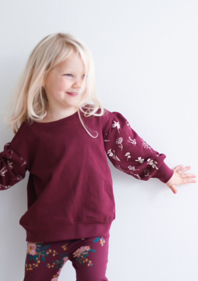 Flower Sketch Bishop Sweater, by Burrow and Be This gorgeous girls sweater is the answer to  how to look fabulous while staying cosy and comfortable! With its bishop sleeve details and pretty floral print, this will quickly become your little girl’s fave outfit for the cooler months.  Pair with the Alpine flowers leggings, or the matching burgandy Flower sketch track pants or even layer up over one of the dresses.