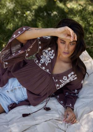 Aneesa Tunic - Cocoa, by Talisman Rendered in a breathable lightweight cotton gauze, this is a style that'll be cherished for seasons to come. Embellished with floral embroidery, this simple beauty can be paired with shorts and skirts, or worn as a throw-over coming off the beach