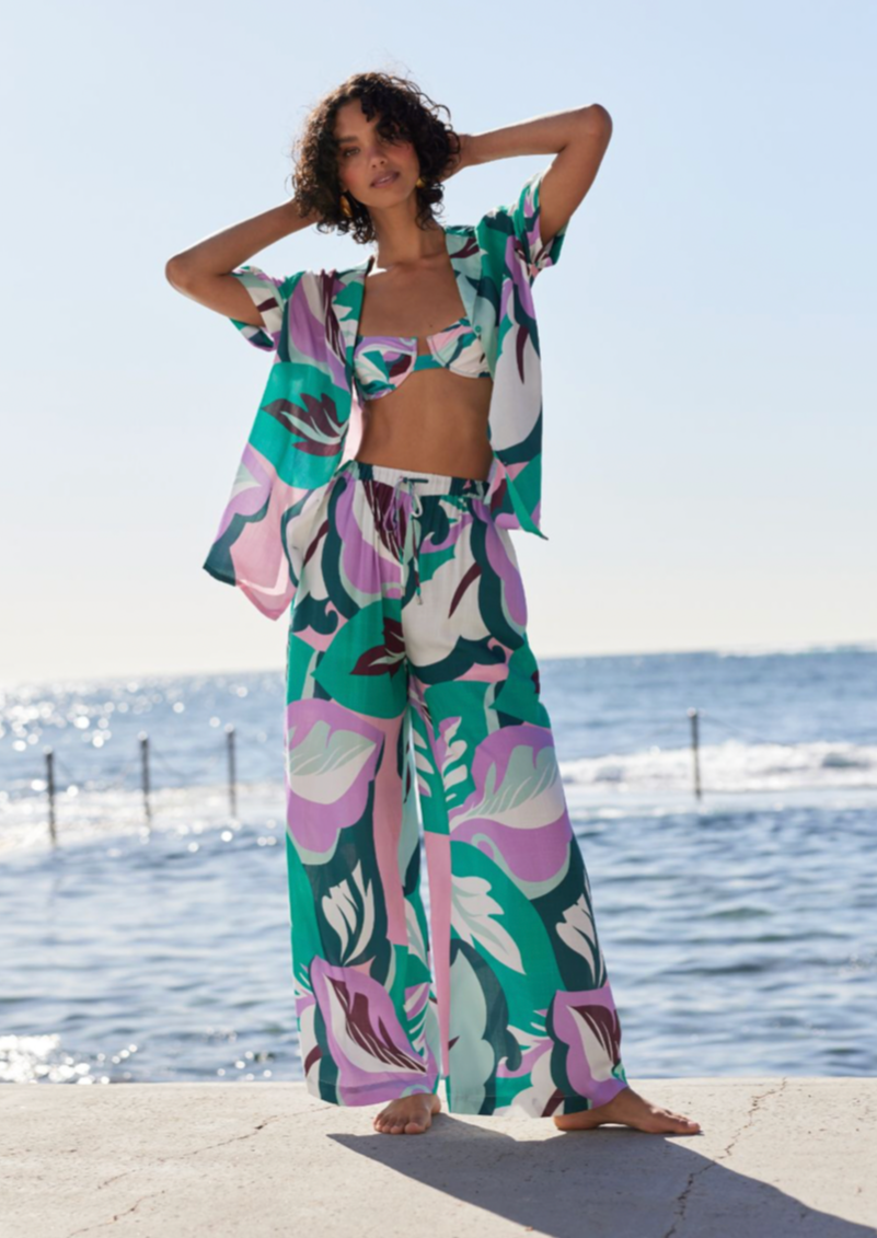Brisa Marina Pant - Lilac/Green, by MinkPink Details:  - Wide-leg drawstring pants in exclusive abstract palm print - High waisted with side pockets. - Encased elastic waistband with self-fabric drawstring - Pair back with Brisa Marina Shirt.