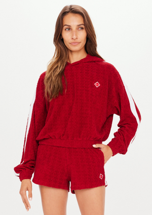 Collegiate Gia Crop Hoodie - Red, by The Upside Be a good sport in the Collegiate Gia Crop Hoodie.  Monogram TU terry towelling jacquard in rich red Cropped hoodie with elasticated hem Contrast white tape down sleeves Embroidered arrow badge Please refer to studio images for accurate colour of garment
