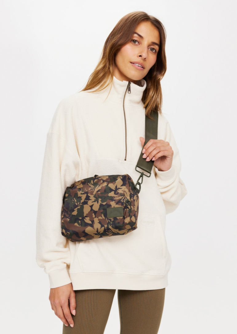 Basecamp Cosmic Crossbody Bag - Camo, by The Upside A compact carry all for all your necessities.  Recycled Polyester crossbody bag printed in our Basecamp camo Fully insulated and lined with internal pocket Chunky zipper with printed arrow at zip puller Adjustable olive green strap Please refer to studio images for accurate colour of garment