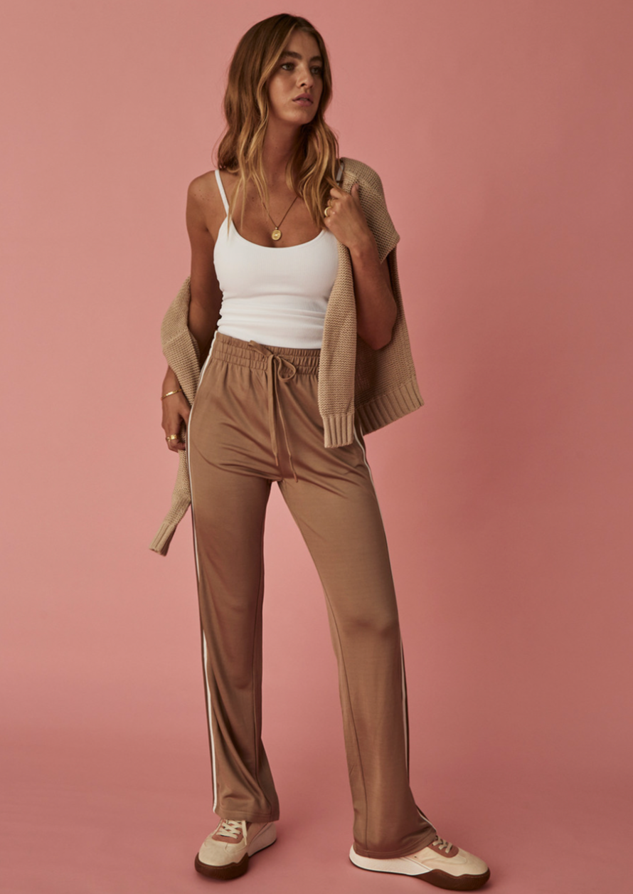 Celeste Pant - Mocha, by The Upside  Evoke French girl ease with our Celeste Pant.  Relaxed fit Mid rise pant Slinky fabrication Straight leg silhouette with elasticated waistband and drawcord Knitted striped tape down side seams Pockets at front and back with embroidered arrow logo