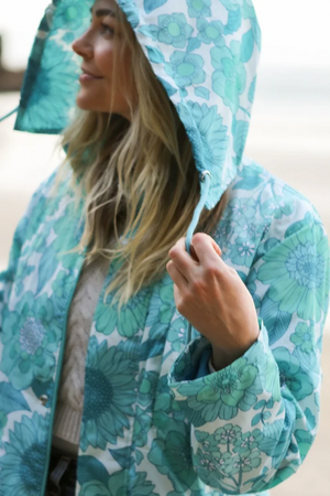 Eco Rain Jacket - Aqua Bloom, by Flock  Introducing our latest innovation in sustainable rain jackets, that are not only sustainable, but are also functional and super cute. Crafted with the environment in mind, our rain jackets have exceptional waterproofing and are also gorgeous, they are made using our floral designs, adding a touch of whimsy to your outdoor adventures. The vibrant blooms not only brighten up rainy days but also serve as a reminder of the natural beauty we strive to protect.