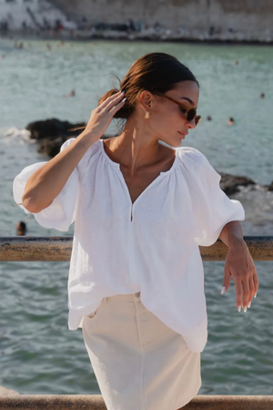 Revolutionary Top - White, by Re:Union

Elevate your wardrobe with the Revolutionary White Linen Top. Crafted from luxurious blue linen, this top exudes elegance and comfort. The relaxed fit allows for effortless style, making it perfect for any occasion. - Relaxed style.

- Clasp Front
- Elasticated Cuffs
- 3/4 Length Sleeve
- 100% Linen
- A conscious choice, This garment is made from natural fibres.