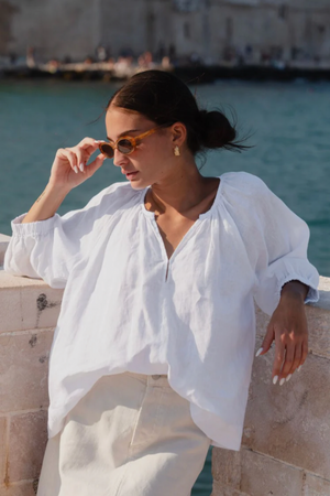 Revolutionary Top - White, by Re:Union

Elevate your wardrobe with the Revolutionary White Linen Top. Crafted from luxurious blue linen, this top exudes elegance and comfort. The relaxed fit allows for effortless style, making it perfect for any occasion. - Relaxed style.

- Clasp Front
- Elasticated Cuffs
- 3/4 Length Sleeve
- 100% Linen
- A conscious choice, This garment is made from natural fibres.