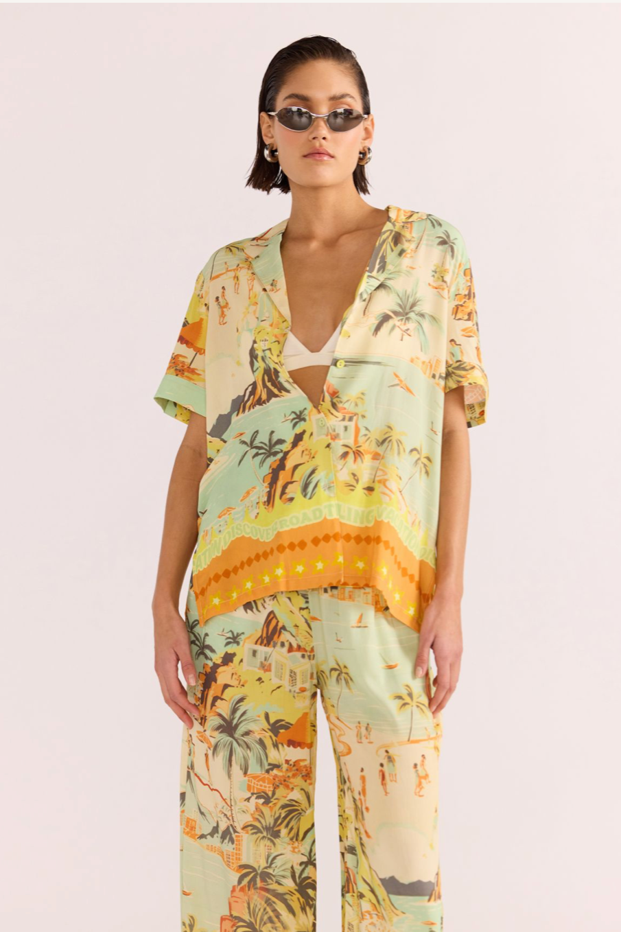 Vacanza Resort Shirt - Tropical, by MinkPink

The Vacanza Resort Shirt can be worn pool-side, as a casual everyday look or dressed up for the evening. This MINKPINK exclusive print features a sketched beachline, full of green-yellow &amp; orange hues. Pair yours with the matching Vacanza Drawstring Pant, to complete the beach to bar look.