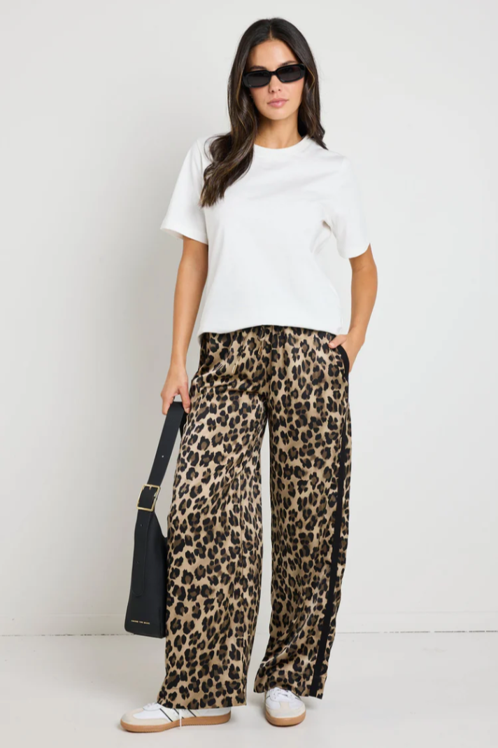 Townie Elastic Waist Satin Pant - Animal, by Stories be Told

Details:

Slip into laid-back luxury with the Townie animal satin black pant. These pants bring a touch of sophistication with their silky smooth satin finish and relaxed fit. The contrast white side stripe adds a modern edge, making them perfect for dressing up or down. Effortlessly chic and endlessly comfortable, they’re a wardrobe staple for the modern woman.