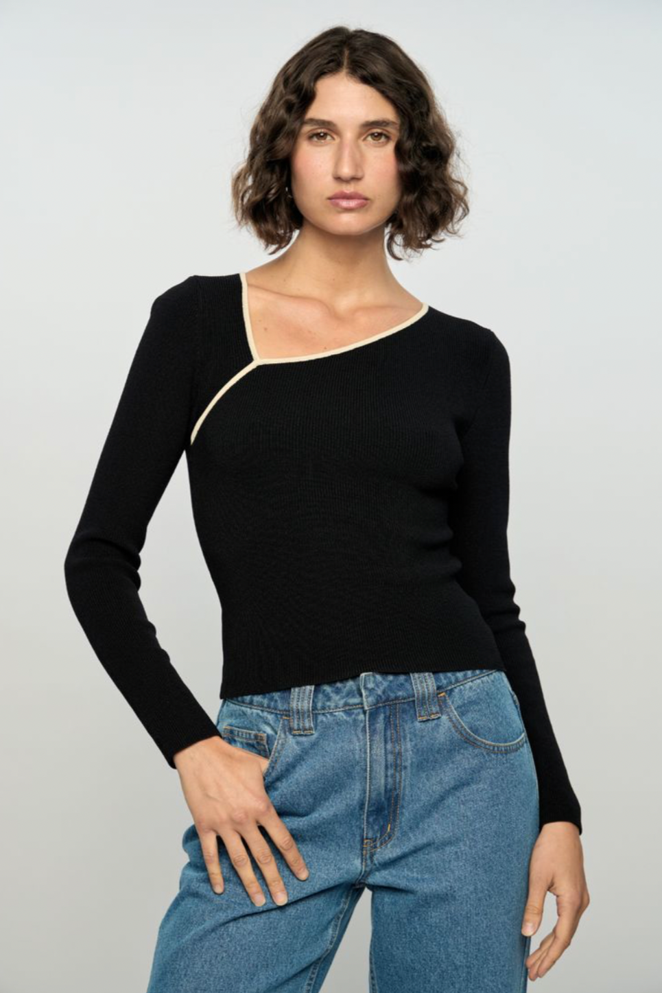 Noelle Knit Top - Black/Cream, by Staple The Label

The Noelle Knit Top in black is a sleek and minimal piece made for layering or wearing solo. Designed in a fine rib with a high neckline, it delivers a streamlined silhouette for any occasion.
- Slim fit
- Long Sleeves
- Asymmetric neckline with cream binding detail
- Fine rib knit texture