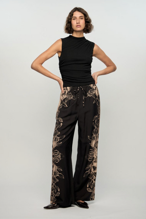 Mira Drawstring Pant - Floral, by Staple The Label

The Mira Drawstring Pant brings relaxed tailoring and statement print together. With a wide leg silhouette and floral border detailing, these lightweight pants are made for elevated off-duty days.