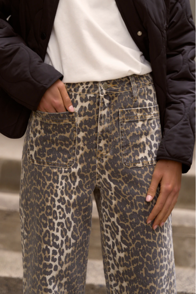 Person wearing leopard print pants with a blurred background
