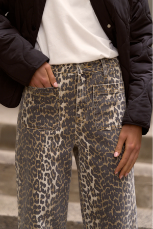 Person wearing leopard print pants with a blurred background