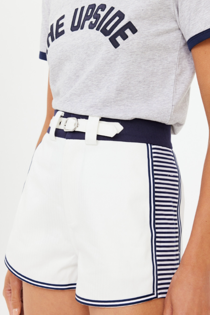 Racer Short - White, by The Upside

A nod to '90s street sport in a classic short silhouette

Vintage inspired short in organic cotton
Navy waistband with built in belt detail at front with metal buckle
Navy white striped side panels
Framed in a mini navy white tape
Back welt pockets
Embroidered arrow logo at back
Please refer to studio images for accurate colour of garment