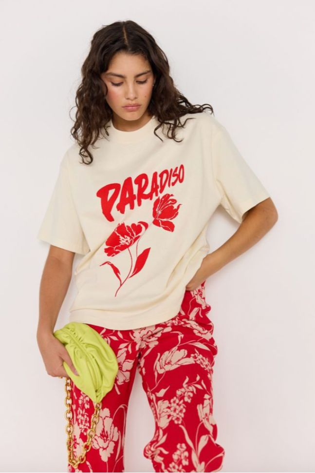 Paradiso Oversize Tee - Cream, by Minkpink

The Paradiso Oversize Tee delivers effortless off-duty energy with a bold graphic twist. Crafted from 100% cotton, it features a relaxed silhouette and red floral print. An easy graphic staple to mix, match and layer.&nbsp;We love this top with denim, over leggings, or paired with the Poppy Pant (shown)