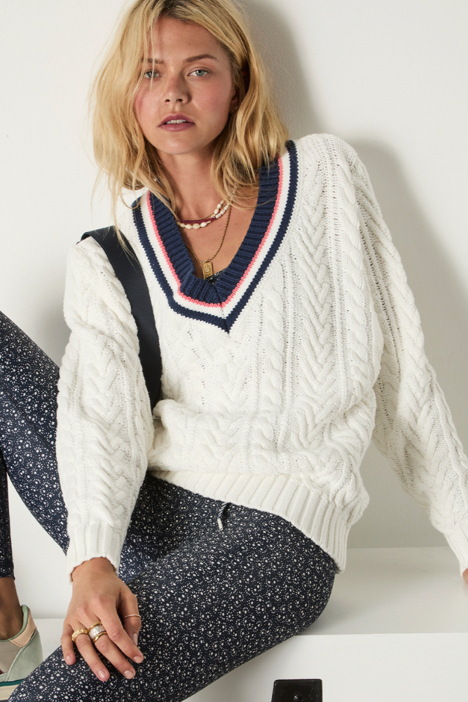 Espada Louie V Neck Sweater - Creme, by The Upside

The Espada Louie V Neck Sweater brings a playful touch to heritage knitwear

Chunky V neck cable knit sweater in cream
Organic cotton knit fabrication
Ribbed cuffs and hem
Contrast striped ribbing at neckline in navy and rose
Arrow logo pip at cuff
Please refer to studio images for accurate colour of garment