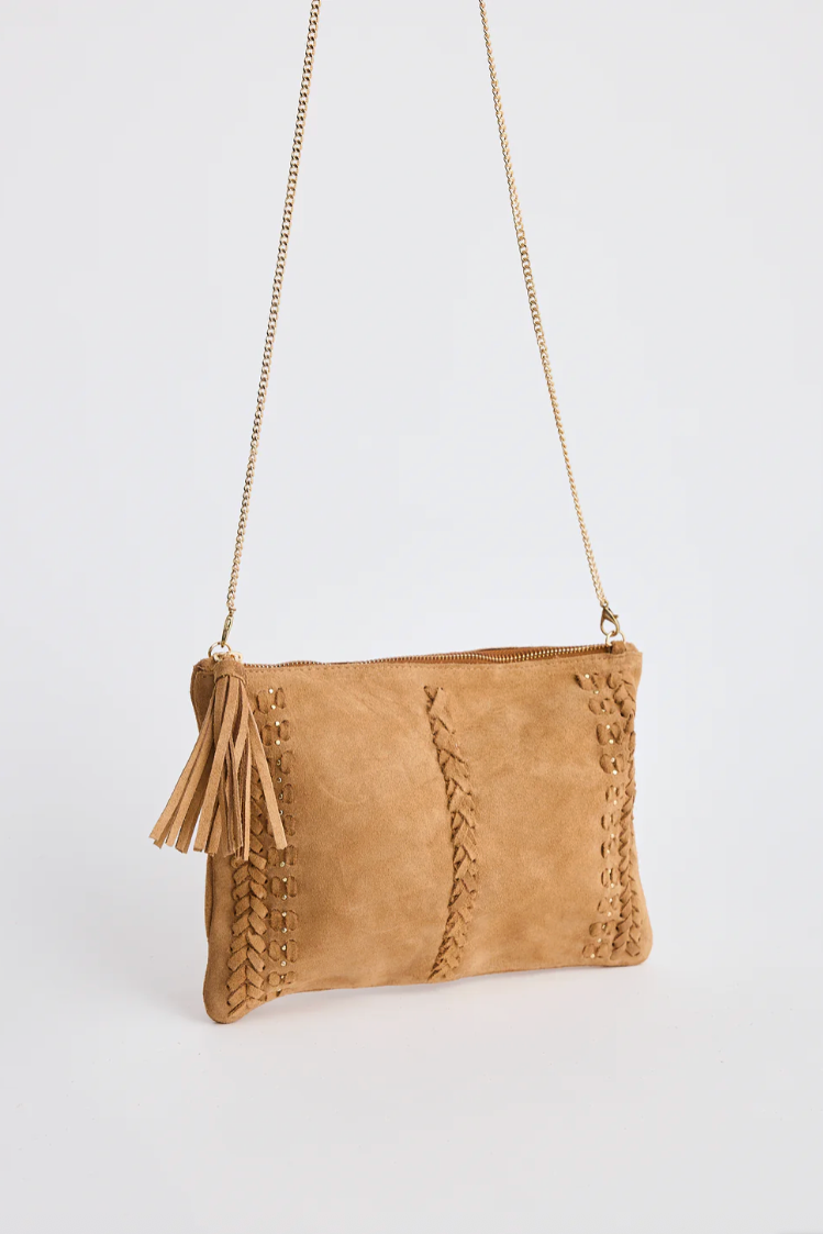 Munroe Suede Leather Bag - Tan, by Holiday

The Munroe Suede Bag in Tan is a versatile and stylish accessory designed to take you from day to night with ease. Featuring soft suede fabric with intricate braided detailing, this bag combines texture with timeless style. The gold chain strap adds a touch of polish, while the tassel zipper pull keeps it relaxed and playful. Spacious enough to hold your essentials, it’s the perfect finishing touch to any outfit. The chain can be removed and the bag used as a clut