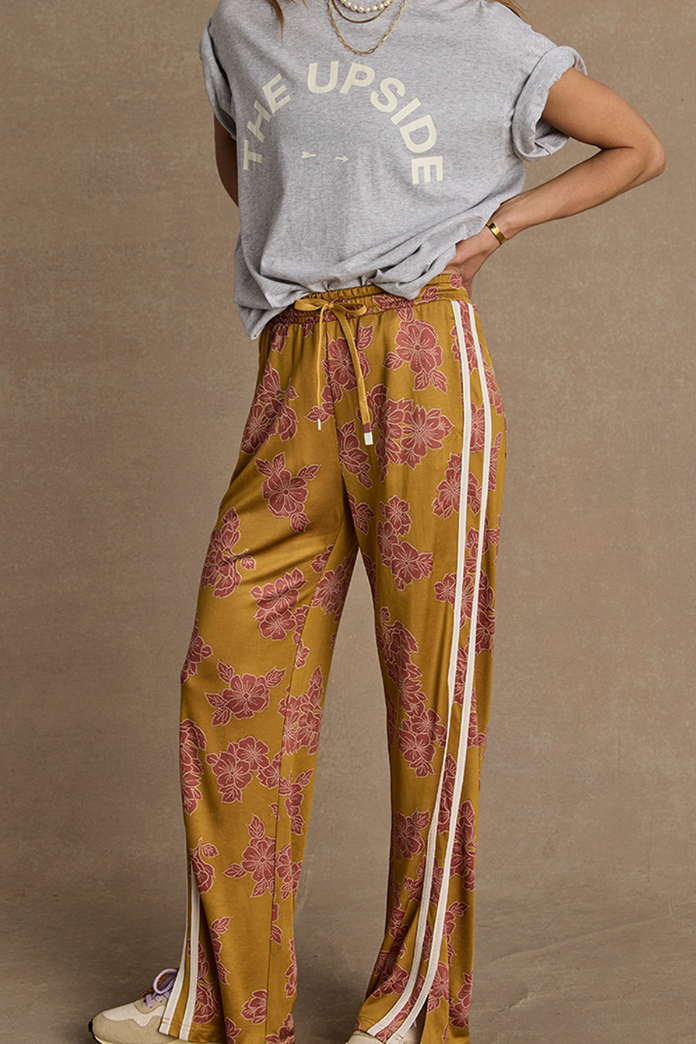 Fantasy Roma Pant - Batik Floral, by The Upside

This seasons batik floral print in an easy, relaxed pant

Highwaisted pant with elasticated waistband in our batik floral print
Double faced single jersey fabrication
Contrast cream binds and split hems
Drawcord and rubber dipped ends
Side seam pockets
Back pockets with logo pip
High Rise
Please refer to studio images for accurate colour of garment