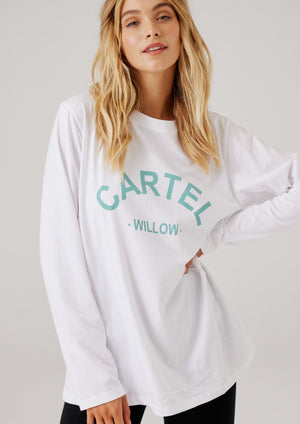 Lola L/S Tee - White, by Cartel & Willow  Details:  Long sleeve, relaxed fit t-shirt Rounded, scoop neckline Large arch logo in sage print on the front chest 100% cotton jersey fabric  Nikki wears a size small and is 173cm tall