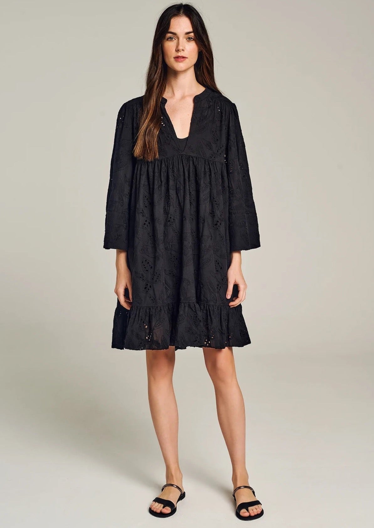 Devotion Symi Dress - Black  For an effortless summer look, choose the Symi Dress from resort wear designer Devotion. Crafted in broderie anglaise cotton, it's the perfect addition to your summer wardrobe.  Details:  V-neck Mini length  All-over embroidery  Side pockets Ruffled hemline
