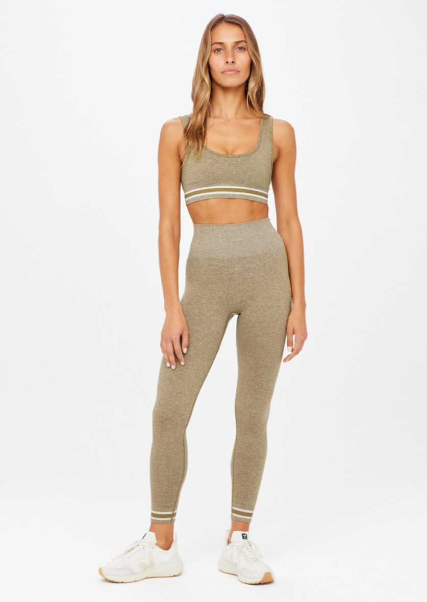 Seamless Midi Pant - Olive Marle, by The Upside Our Seamless Dance Midi Pant has all the smooth moves..  High-rise 7/8 length legwear Olive marle seamless fabrication Contrast knitted stripes down sides Tonal arrow logo on back Moisture control properties
