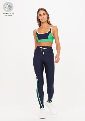 Kala Yoga Pant - Navy, by The Upside Find your bliss in our Kala Yoga Pant.  Full length leg wear in navy Contrast curved panels at sides with piping Arrow logo at centre back Colour blocked in our Eco Tech performance fabric Breathable, quick drying and moisture wicking Tonal drawcord through waist