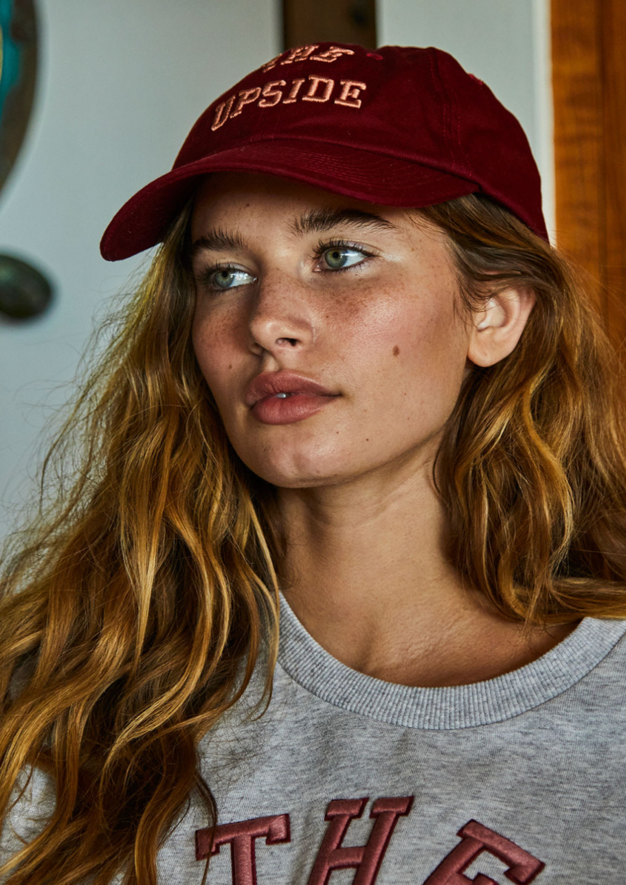 Academy Soft Cap - Mulberry, by The Upside Be super sun chic in our Academy Soft Cap  Soft retro fit cap in mulberry red 'THE UPSIDE' embroidered preppy logo at front Adjustable velcro strap at back Organic cotton twill fabric
